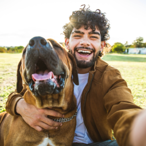 young man in brown shirt with smiling dog